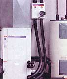 A hot water unit and pump (above). Coring a path into the house. A 2"" hole is drilled through the foundation. A 2"" PVC sleeve is inserted and watersealed.